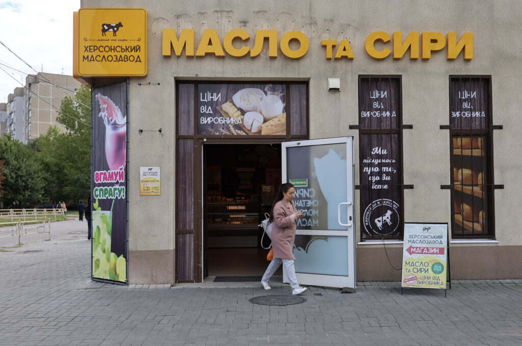 Жінка виходить з фірмової крамниці Херсонського маслозаводу