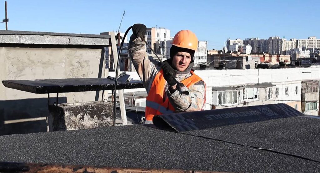 В Одесі відновили пошкоджену 1 січня 2024 року багатоповерхівку 2 Будівельник улаштовує покрівлю будинку в Одесі