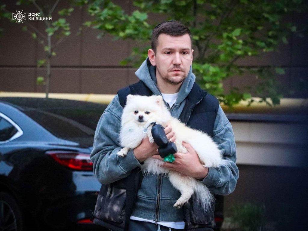 Через масовану атаку на Київ загинули двоє людей: що відомо про обстріл регіону 6 Житель Софіївської Борщагівки тримає собаку на руках